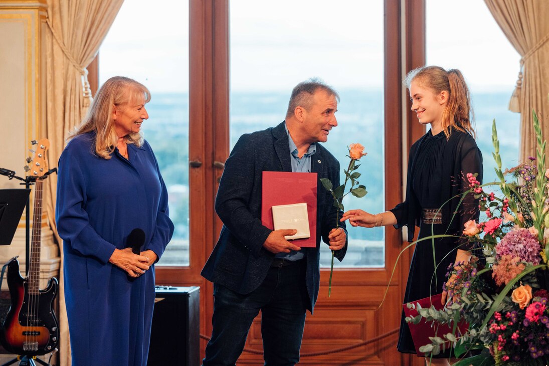 Annen-Medaille 2025: Schülerin übergibt Rose an Preisträger, daneben Staatsministerin Petra Köpping