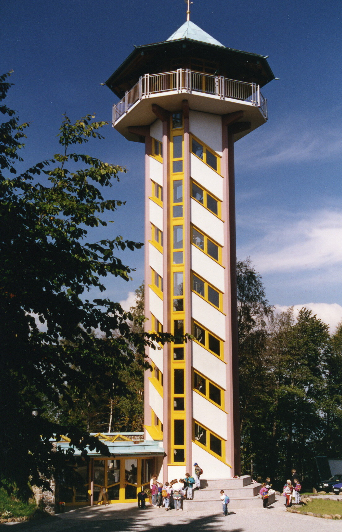 Foto des Aussichtsturms Scheibenberg bei Sonnenschein mit einigen Besuchern
